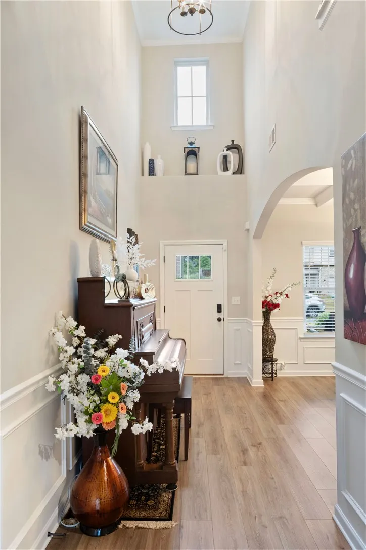 Enter into a bright, inviting foyer with elegant wainscoting and warm flooring.