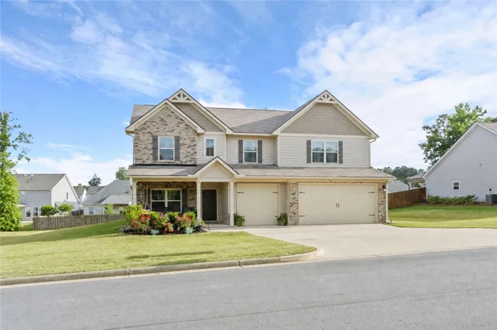 This charming residence features a well-maintained lawn and a welcoming facade.
