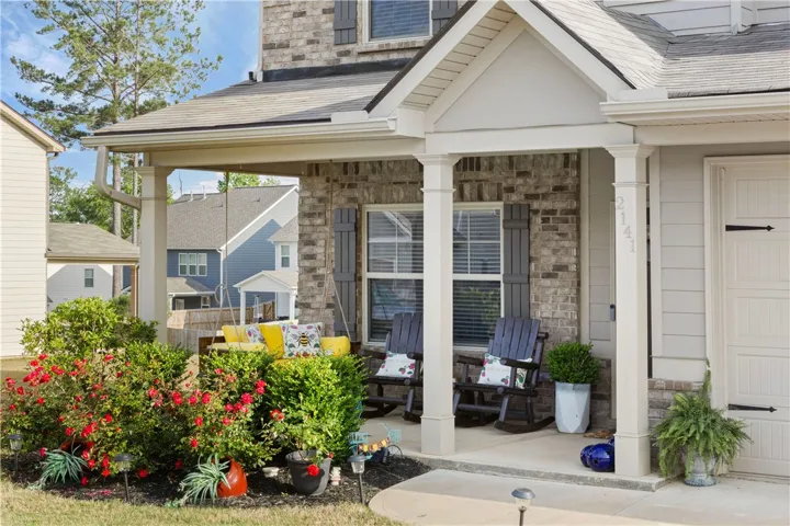 This inviting home features a covered porch with ample space for relaxation and enjoying the outdoors.