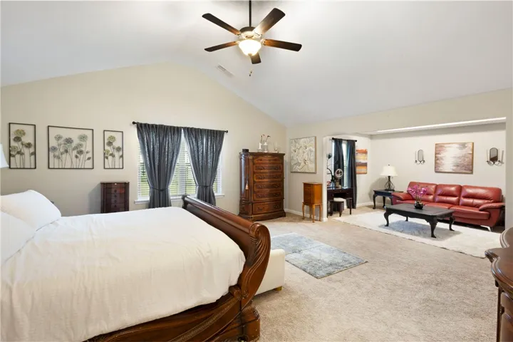 This spacious primary bedroom features vaulted ceilings and ample room for both rest and relaxation.