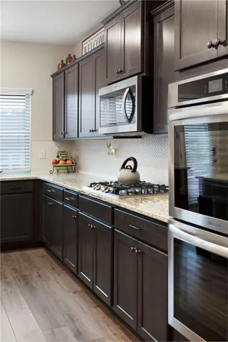 This modern kitchen features rich cabinetry, sleek appliances, and elegant countertops.