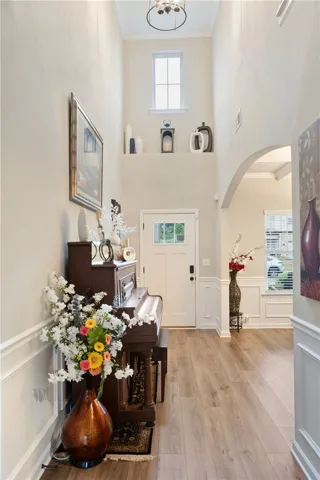 Enter into a bright, inviting foyer with elegant wainscoting and warm flooring.