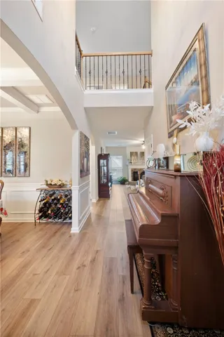 Elegant entrance hallway with high ceilings and rich flooring leads to an inviting living space.