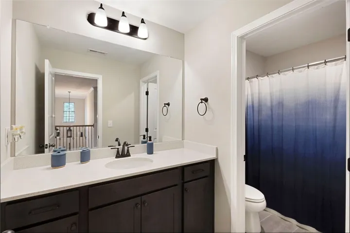 This bright bathroom features a spacious vanity with elegant fixtures.