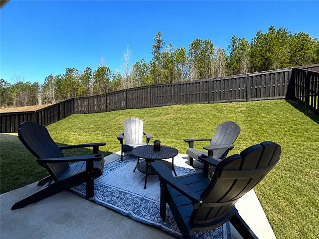 This spacious backyard features a privacy fence and ample green space, ideal for outdoor enjoyment.