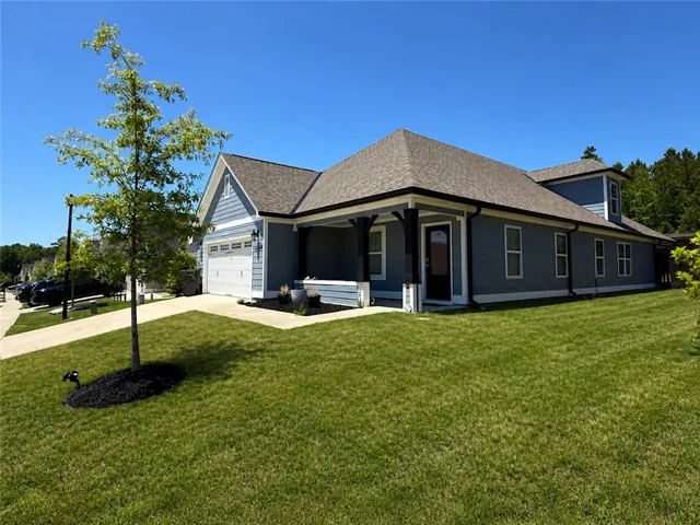 This charming residence features a well-maintained lawn, inviting porch, and an attached garage.