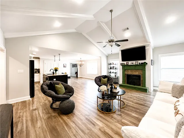 This living area features a striking fireplace and vaulted ceilings, creating an open and airy atmosphere.