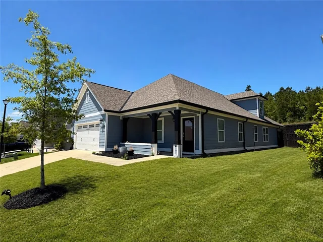 This charming home features a well-manicured lawn and inviting porch, perfect for enjoying sunny days.