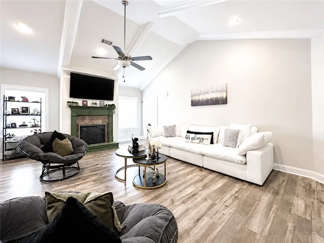 This living room features vaulted ceilings and rich wood flooring, perfect for comfortable gatherings.