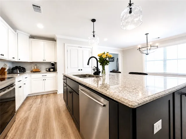This bright kitchen features sleek appliances, an expansive island, and ample cabinetry for effortless living.