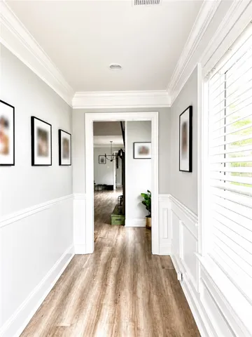 This bright hallway features rich flooring and elegant architectural details.