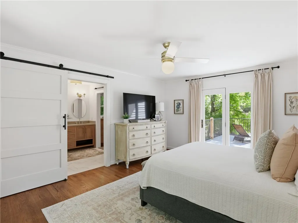 This tranquil bedroom features outdoor access, a beautiful bathroom, and sleek hardwood floors.
