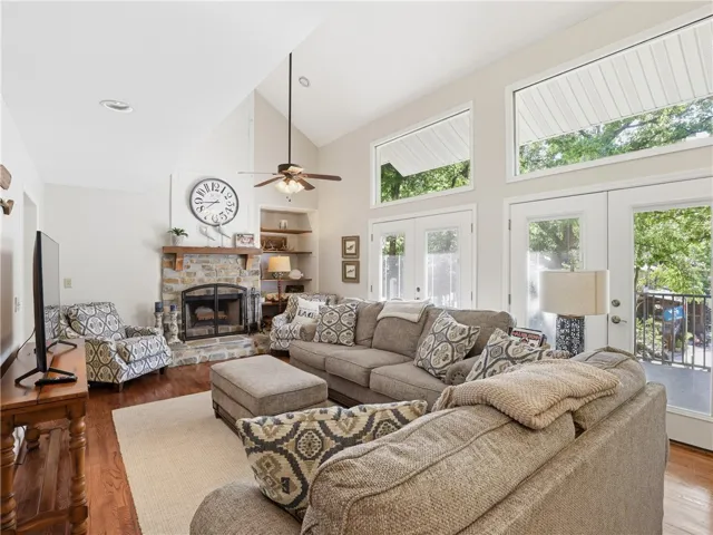 This living room features high ceilings and a stone fireplace, creating an inviting atmosphere for daily living.