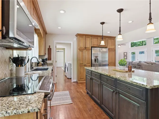 This kitchen features a central island, rich cabinetry, and a bright, open flow.