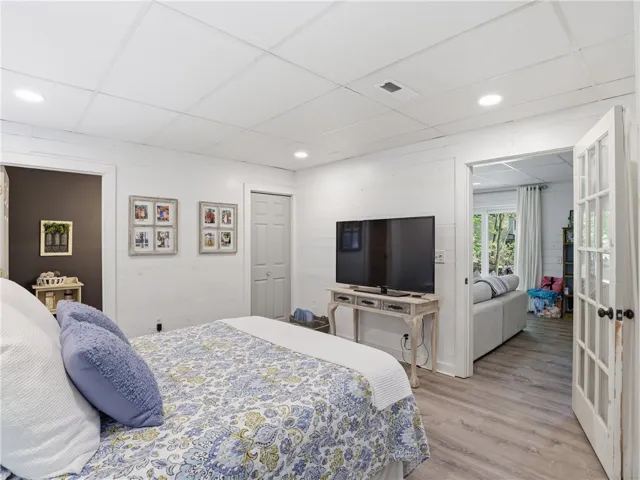 This cozy bedroom features durable flooring and convenient access to a bright living space.