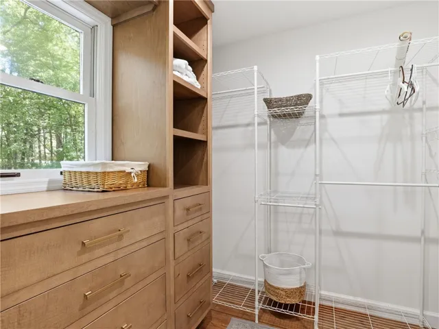 This spacious walk-in closet offers ample storage with built-in cabinetry and shelving.