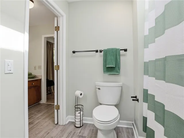 This clean and inviting bathroom features wood-look tile flooring and modern fixtures.