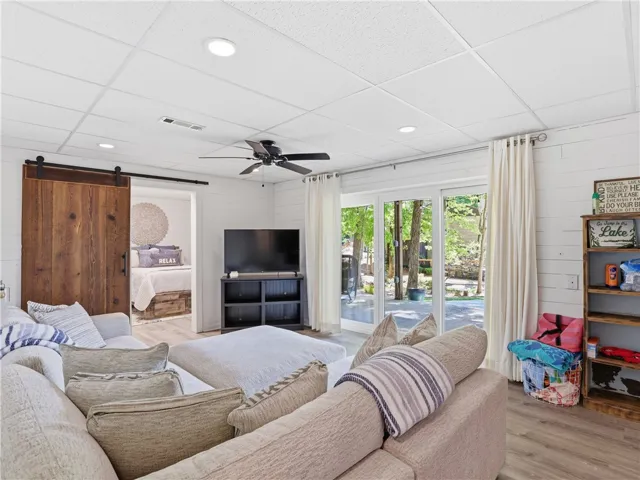 This living area features a barn door and sliding glass doors that open to the outdoors.