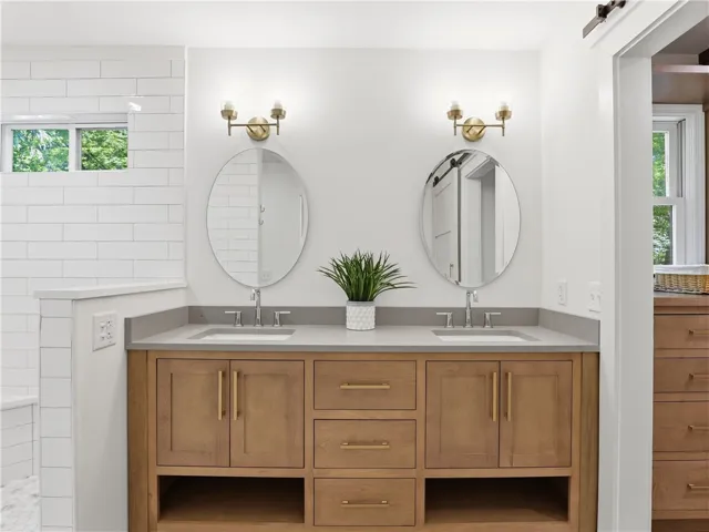 This primary bathroom features a dual vanity, sleek mirrors, and contemporary lighting.
