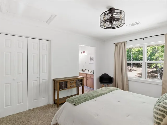 This peaceful bedroom offers ample space, inviting comfort, and a private retreat with scenic views.