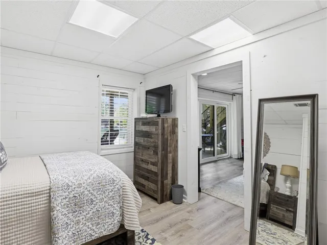 This cozy bedroom offers a tranquil retreat with wood-planked walls and direct outdoor access.