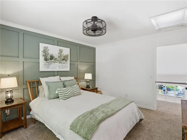 This tranquil bedroom features plush carpeting and elegant crown molding, creating a serene personal retreat.
