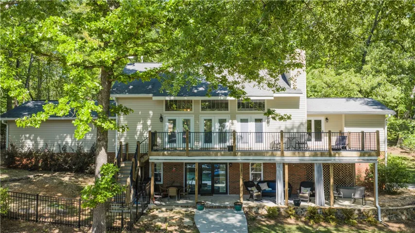 This home features a deck perfect for outdoor enjoyment, blending seamlessly with the surrounding trees.