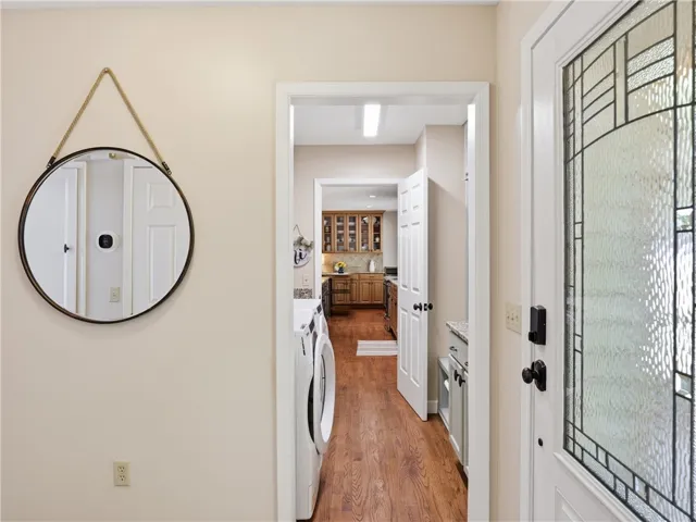 This functional hallway features convenient laundry appliances and leads to a well-appointed kitchen.