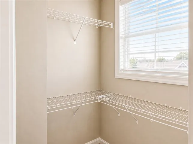 This spacious walk-in closet features ample storage and natural light through the window.