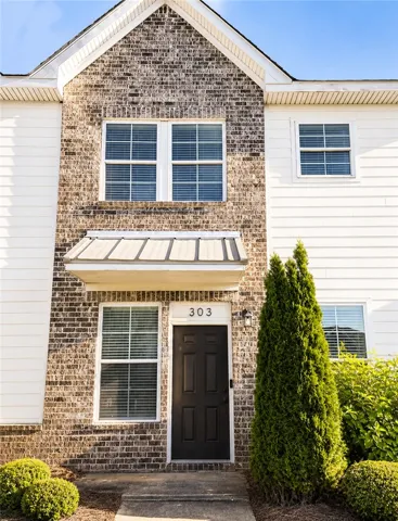 This charming home features a brick and siding exterior with inviting landscaping.