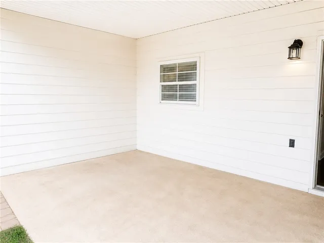 This private patio offers a versatile outdoor living space with durable siding and a clean concrete surface.