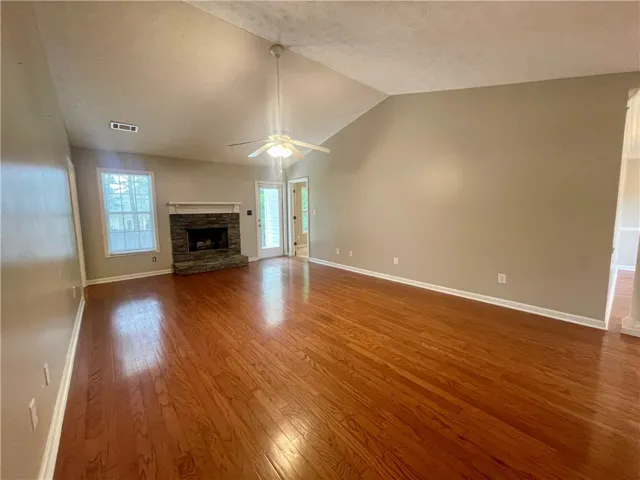 This airy living space features a cozy fireplace and gleaming hardwood floors, perfect for relaxation.