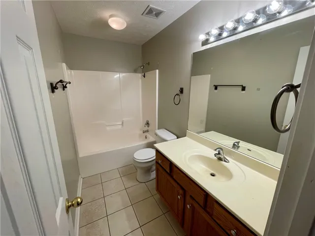 This functional bathroom features a tub, shower, and spacious vanity.