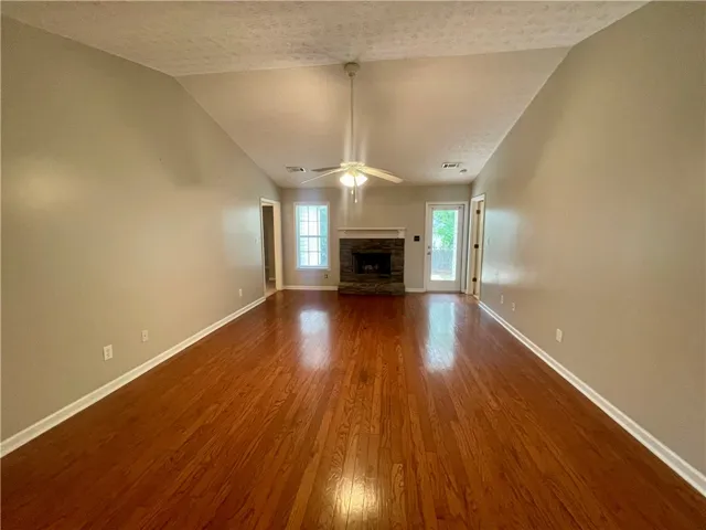 This inviting living room features gleaming hardwood floors and a cozy fireplace, perfect for relaxation.