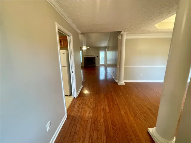 This interior hallway features warm wood flooring and architectural columns.