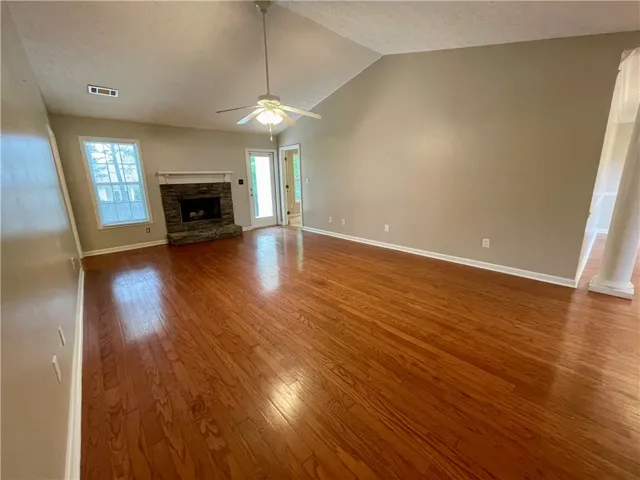 This inviting living space features gleaming hardwood floors and a cozy stone fireplace, perfect for gatherings.