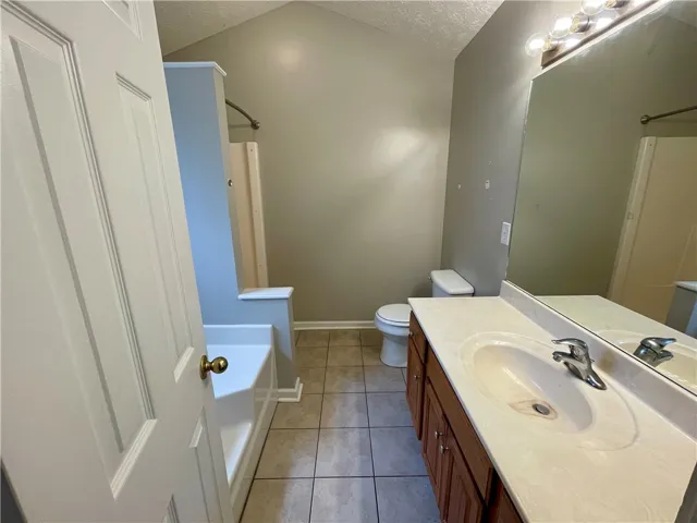This functional bathroom features practical design and tiled flooring.