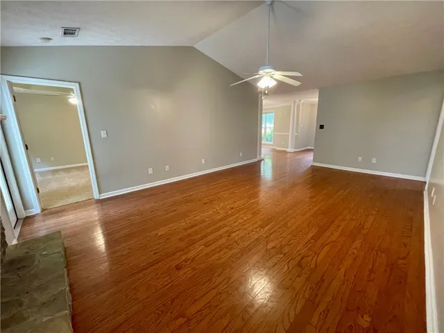 This expansive living area features lustrous hardwood flooring and soaring vaulted ceilings.