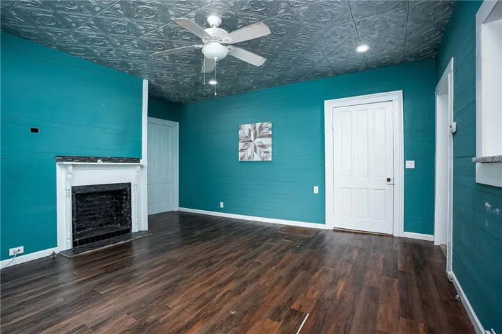 This inviting room features rich wood flooring, a fireplace, and a distinctive ceiling, offering comfort and style.
