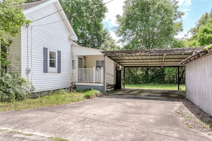 This charming home offers a welcoming porch and a convenient carport for sheltered parking.