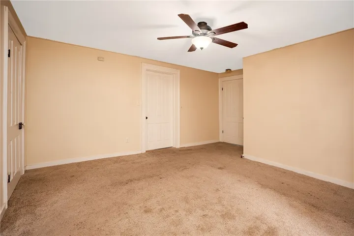This spacious room features cozy carpeting and elegant paneled doors.