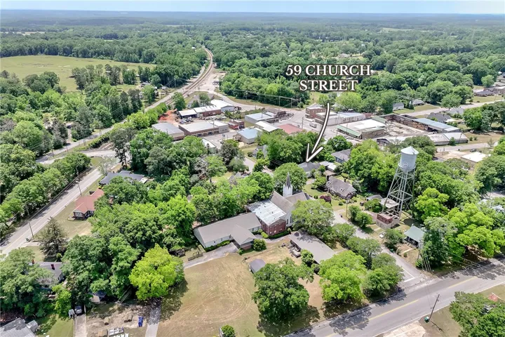 An aerial perspective reveals a charming town nestled amidst lush greenery and open spaces.