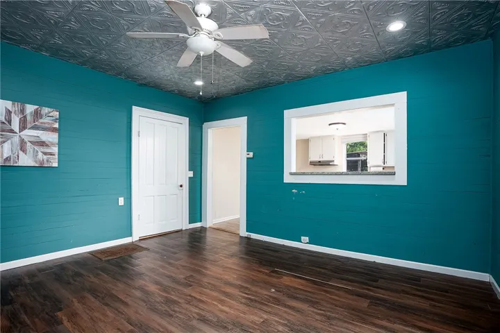 This vibrant room features rich flooring and a unique patterned ceiling.