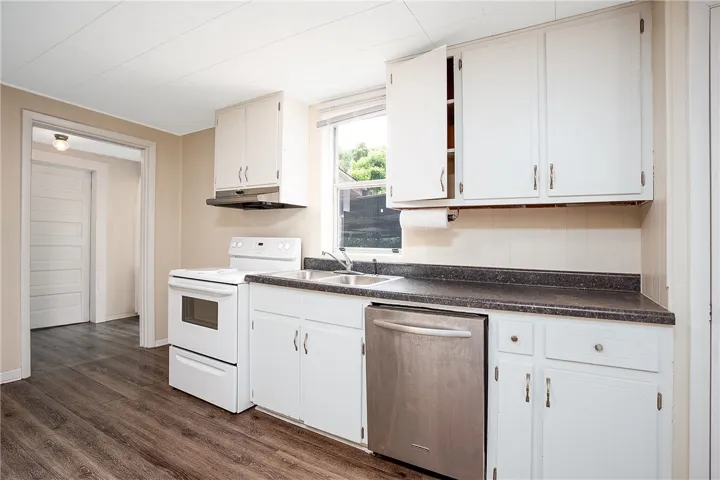 This functional kitchen features white cabinetry and dark countertops, ready for your culinary creations.