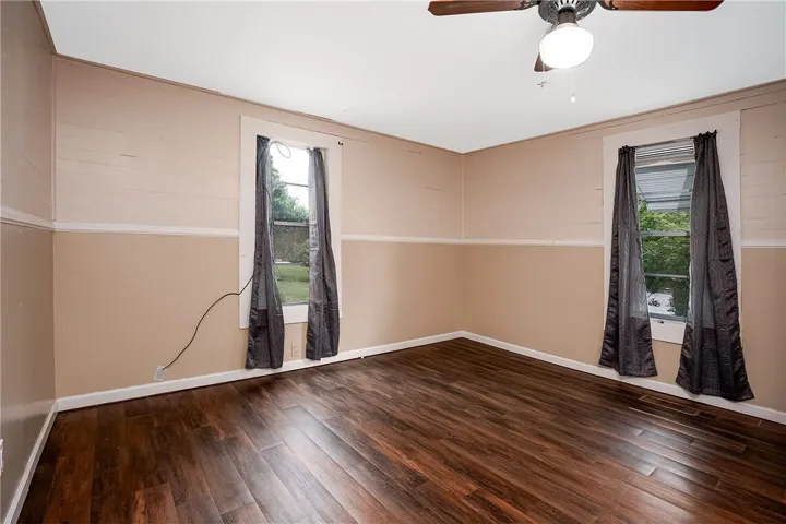 This inviting bedroom features rich hardwood flooring and abundant natural light.