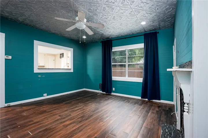 This vibrant living space features decorative ceilings and rich wood flooring, perfect for comfortable gatherings.