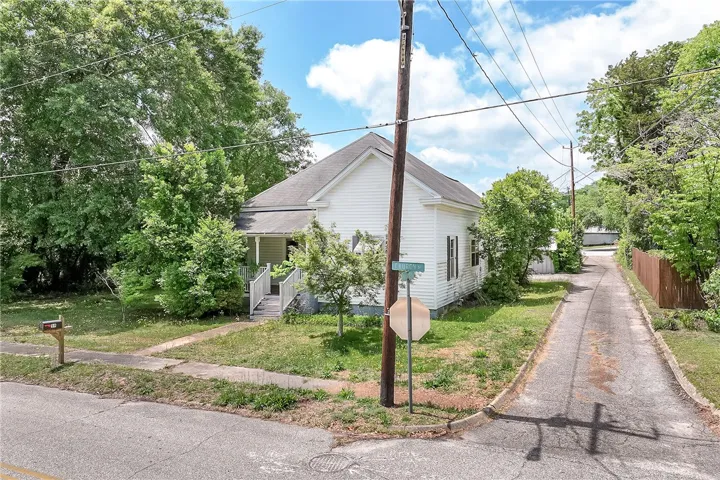 This charming home features a classic exterior and lush landscaping, offering a serene living environment.