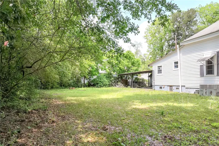 This spacious yard offers a serene retreat with ample green space and mature trees.