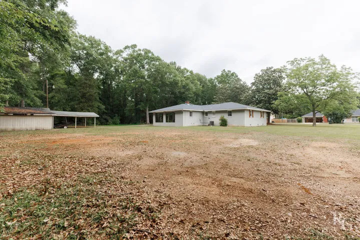 This spacious backyard with mature trees offers endless possibilities for outdoor enjoyment.