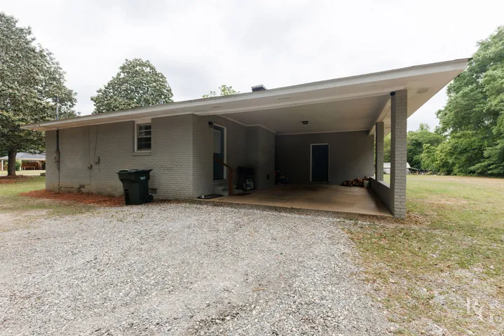 This residence features a convenient carport, ideal for sheltered parking and easy access to the home.
